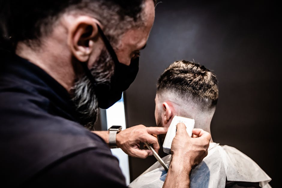 Barber performing a detailed haircut, showcasing precision and skill in an indoor setting.